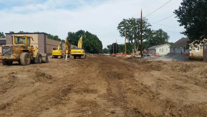 Paved road torn out with excavators ready to work
