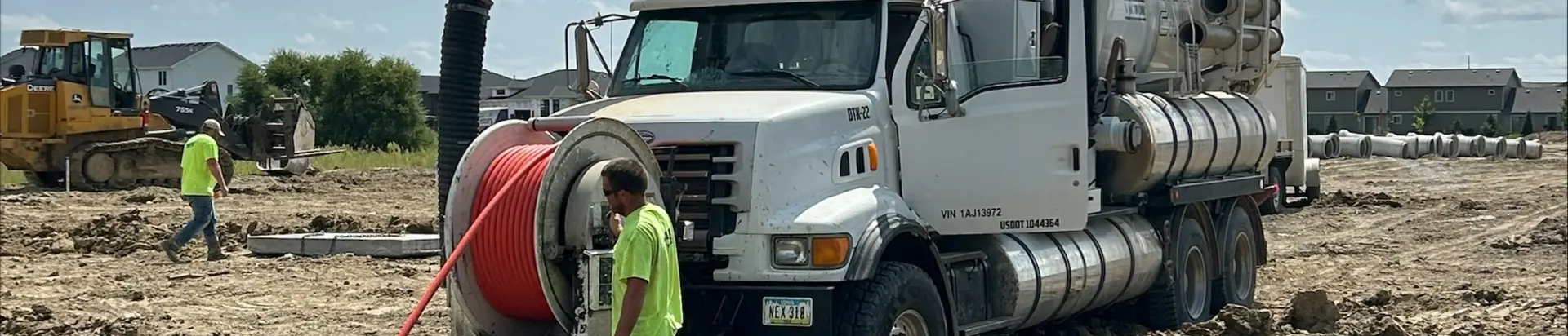Man feeding pipe with machine into the ground