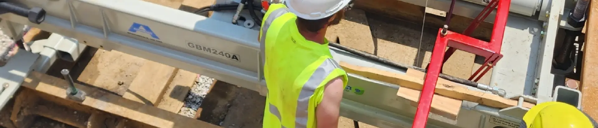 Man working machinery in a dug out ditch