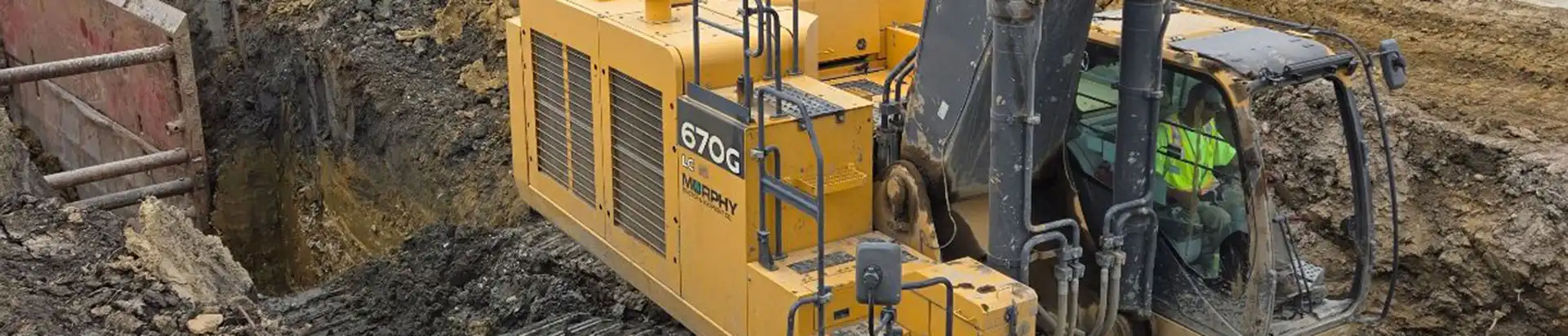 Two yellow excavators in the woods in a construction site